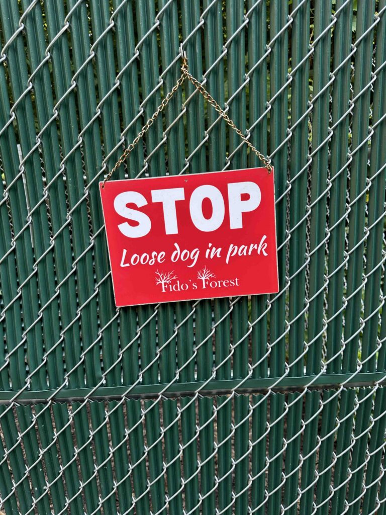 loose dog in park sign